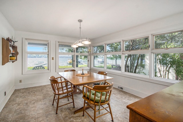 dining space featuring plenty of natural light and a water view