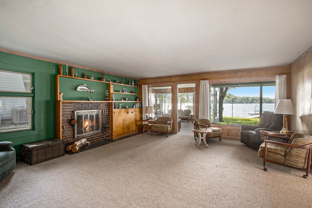 living room featuring a water view, carpet floors, and a brick fireplace