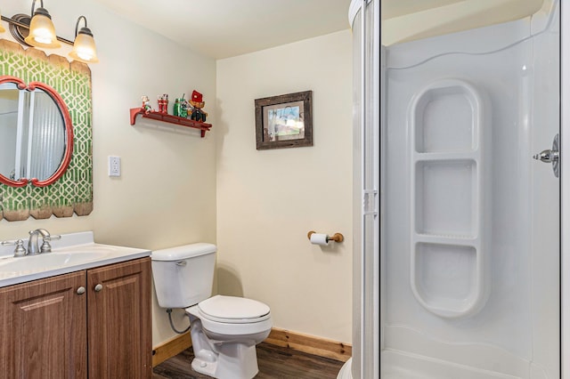 bathroom with a shower, hardwood / wood-style floors, vanity, and toilet