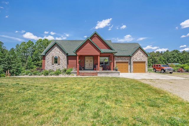 view of front of property with covered porch, a garage, and a front yard