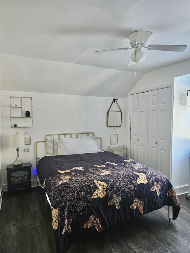 bedroom featuring dark wood-style flooring, a closet, a ceiling fan, vaulted ceiling, and baseboards