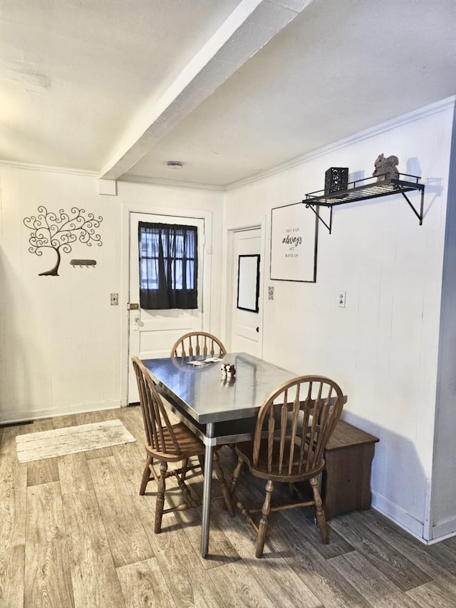 dining room with ornamental molding and wood finished floors