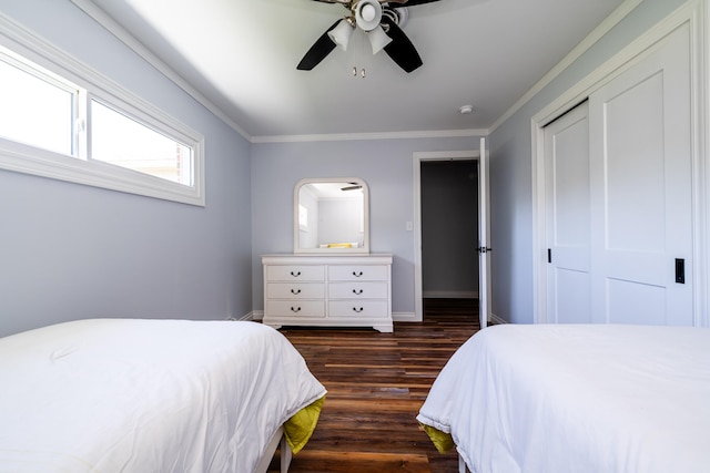 bedroom featuring ceiling fan, crown molding, dark wood-type flooring, and a closet