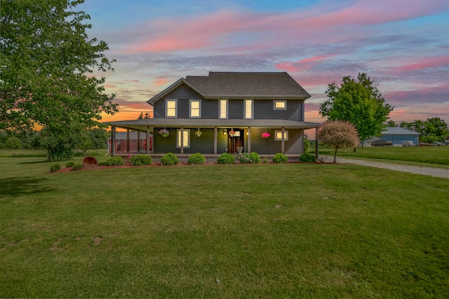 view of front of home featuring covered porch and a yard