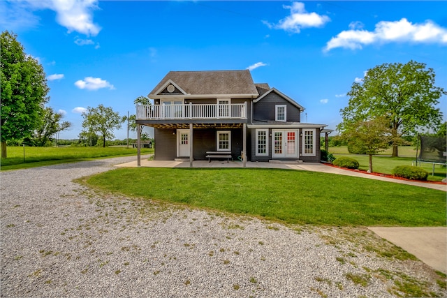 back of property with a lawn, a patio area, a trampoline, and a deck