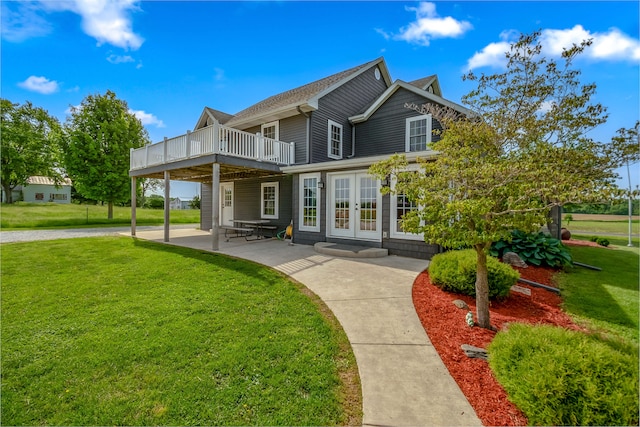 rear view of property featuring french doors, a patio, a deck, and a lawn