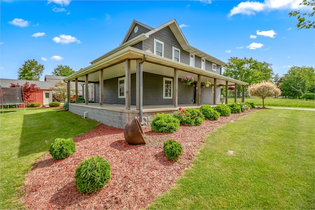 view of property exterior with a porch, a yard, and a trampoline