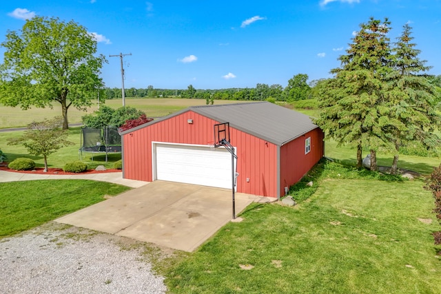 garage with a trampoline and a lawn