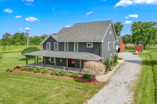 view of front of home with a front yard, a porch, and a storage shed