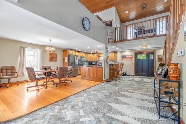 interior space featuring light hardwood / wood-style floors, wood ceiling, high vaulted ceiling, and an inviting chandelier