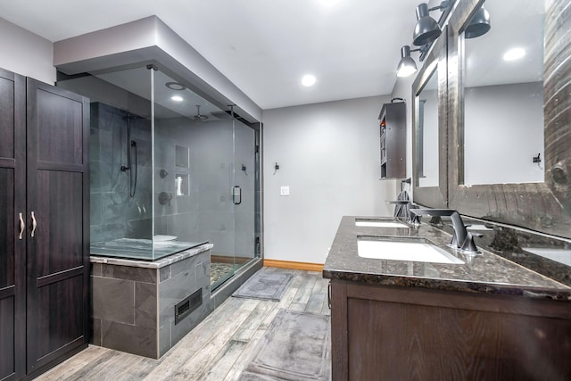 bathroom featuring hardwood / wood-style flooring, vanity, and a shower with door