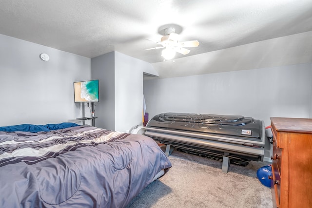 bedroom with ceiling fan, light colored carpet, and a textured ceiling