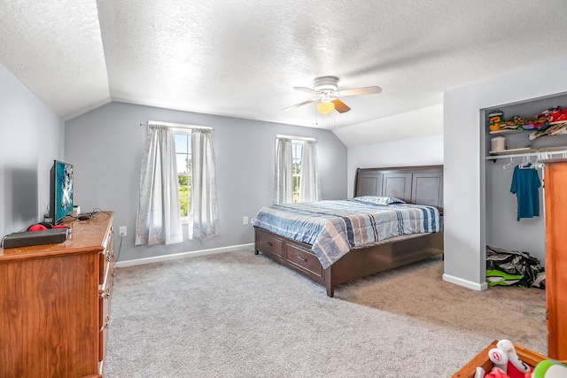 carpeted bedroom featuring a textured ceiling, ceiling fan, a closet, and lofted ceiling