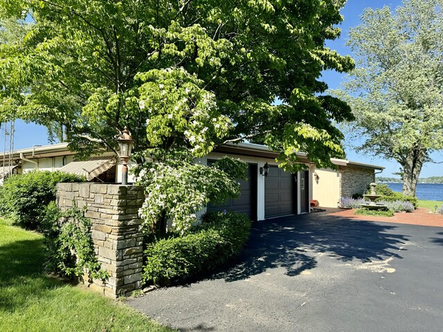 7206 Beechwood Cir, Watervliet, MI 49098 - view of front facade with asphalt driveway, a garage, and a water view