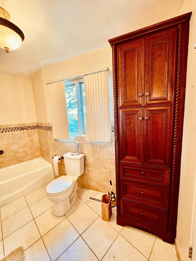 7206 Beechwood Cir, Watervliet, MI 49098 - bathroom with tile patterned flooring, a garden tub, toilet, tile walls, and a closet