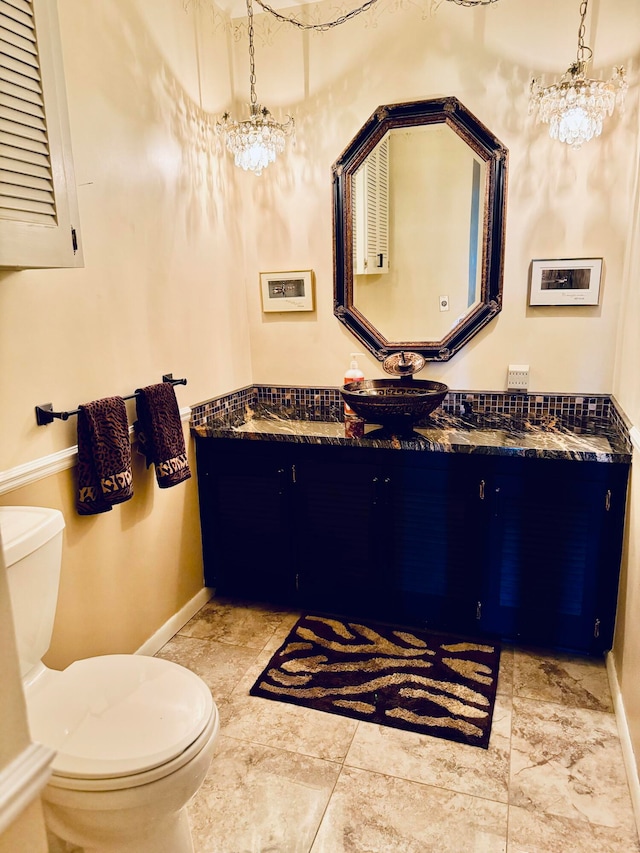 bathroom with vanity, a chandelier, and toilet