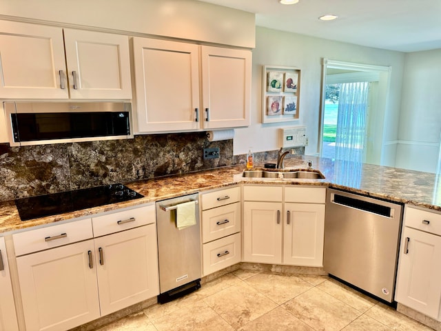 kitchen with light stone countertops, sink, white cabinets, and appliances with stainless steel finishes