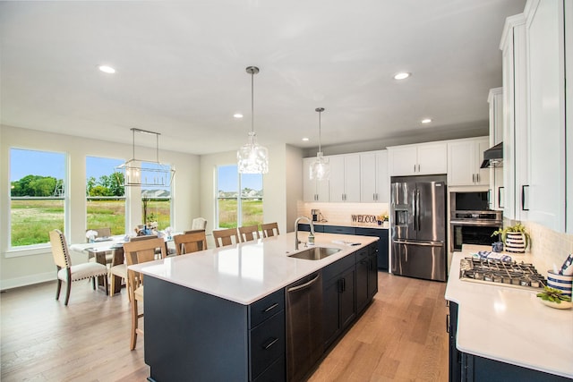 kitchen featuring a healthy amount of sunlight, a kitchen island with sink, sink, and stainless steel appliances