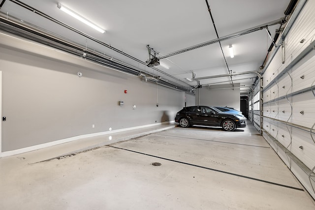 garage with a garage door opener and baseboards