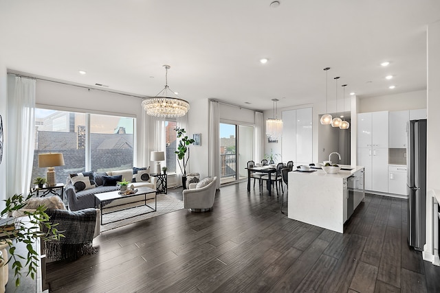 living room with dark hardwood / wood-style flooring, a chandelier, and sink