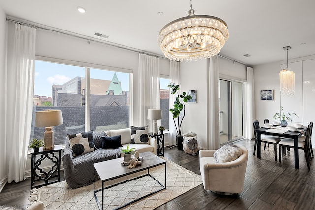 living room with dark wood-type flooring and an inviting chandelier