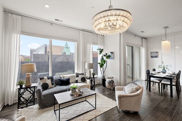 living area featuring recessed lighting, a city view, visible vents, a notable chandelier, and wood finished floors