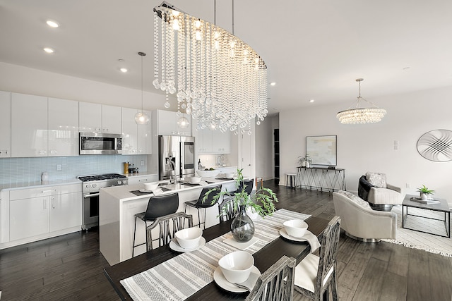 dining room with an inviting chandelier, dark wood-style flooring, and recessed lighting