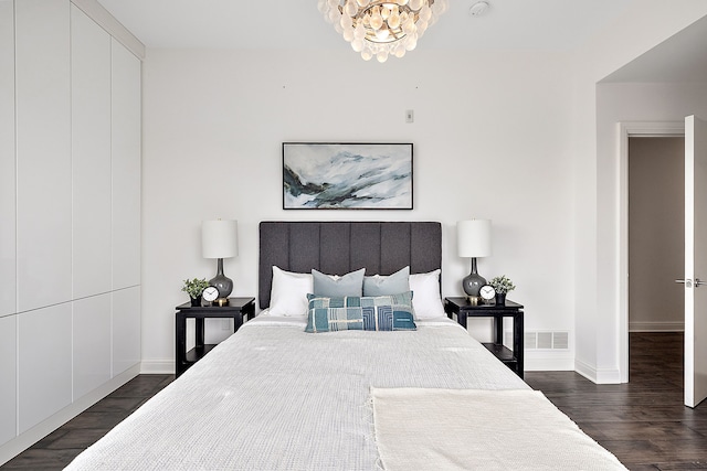 bedroom with baseboards, visible vents, dark wood-style flooring, and a chandelier