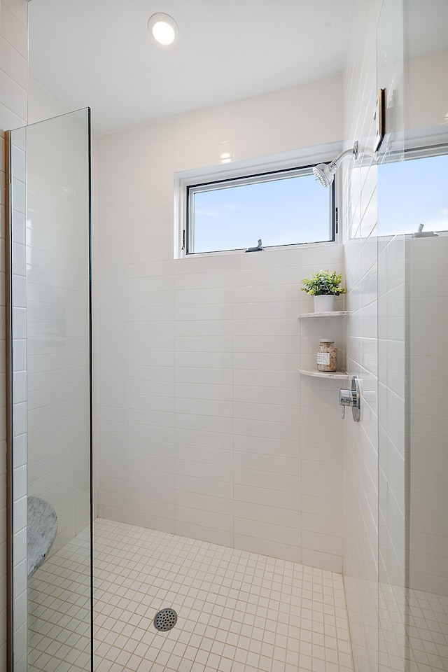 full bath with a tile shower and a wealth of natural light