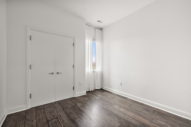 unfurnished bedroom featuring a closet and hardwood / wood-style floors