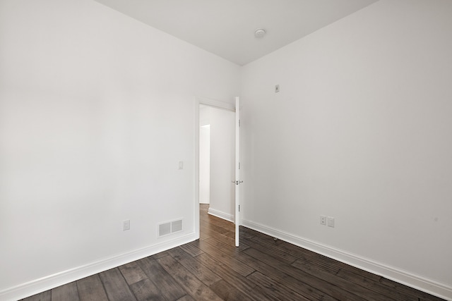 spare room with dark wood finished floors, baseboards, and visible vents