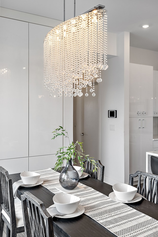 dining area featuring wood finished floors and an inviting chandelier