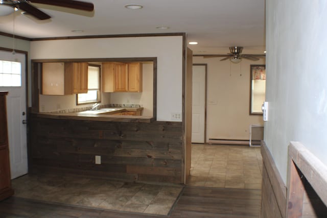 kitchen with ceiling fan, sink, a baseboard heating unit, crown molding, and hardwood / wood-style flooring