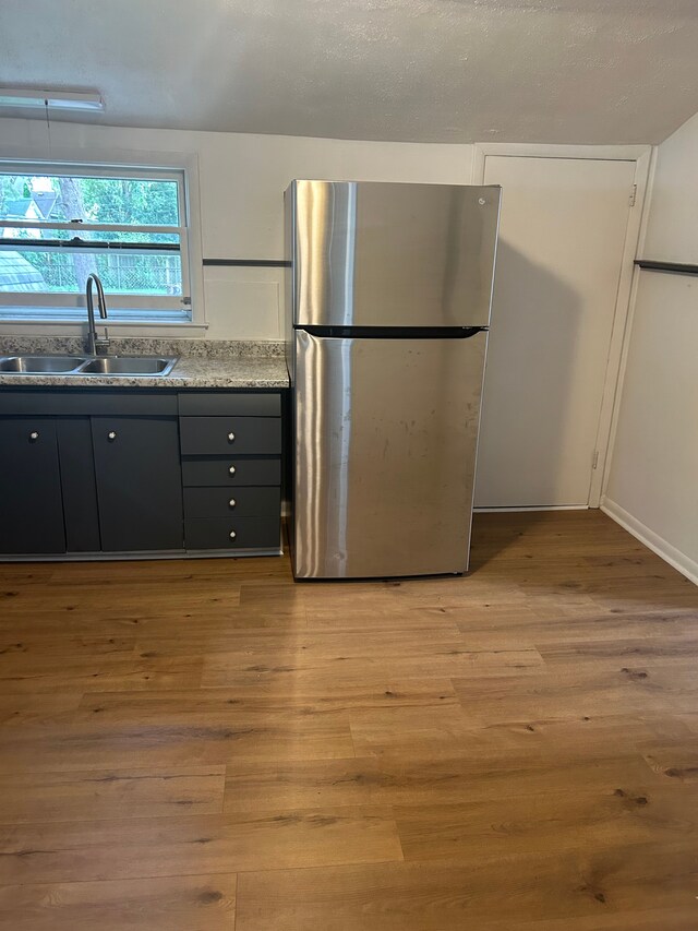 1114 Church St, Port Huron, MI 48060 - kitchen with freestanding refrigerator, a sink, light wood-type flooring, and gray cabinets