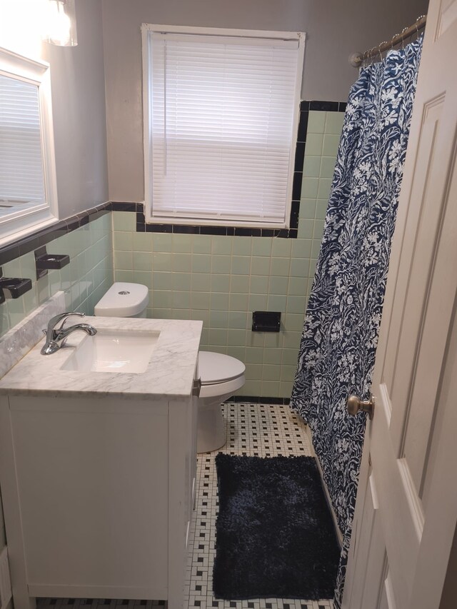 11675 Forrer St, Detroit, MI 48227 - full bath featuring vanity, toilet, a wainscoted wall, tile walls, and tile patterned floors