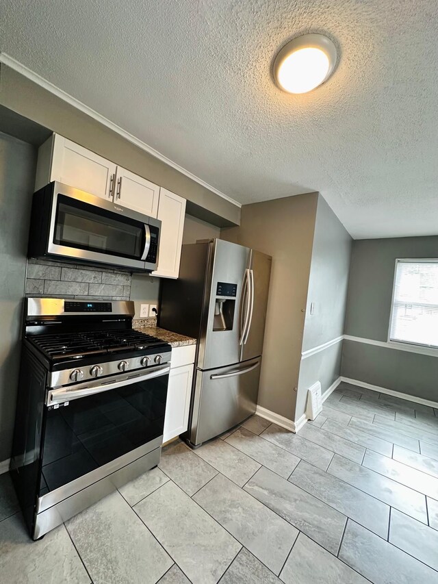 11675 Forrer St, Detroit, MI 48227 - kitchen featuring appliances with stainless steel finishes, white cabinets, baseboards, backsplash, and a textured ceiling