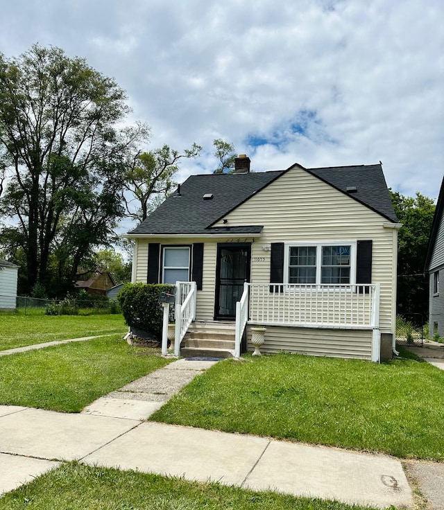 11675 Forrer St, Detroit, MI 48227 - bungalow-style house featuring a front yard, a chimney, roof with shingles, and covered porch