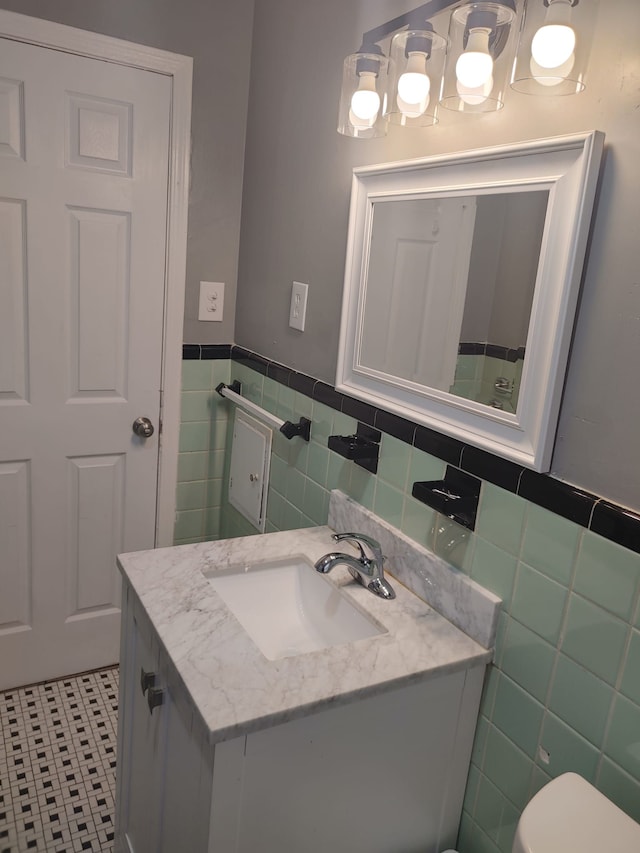 11675 Forrer St, Detroit, MI 48227 - bathroom with tile walls, vanity, wainscoting, tile patterned flooring, and toilet