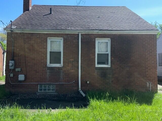 18659 Shaftsbury Ave, Detroit, MI 48219 - view of property exterior featuring a chimney, brick siding, and a shingled roof