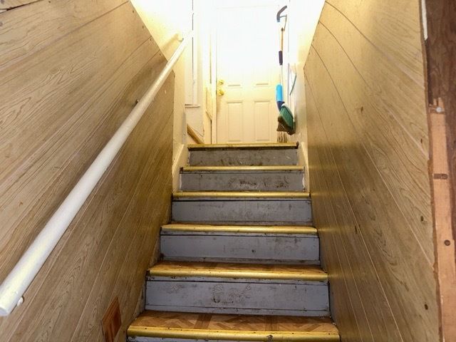 staircase featuring hardwood / wood-style floors and wood walls