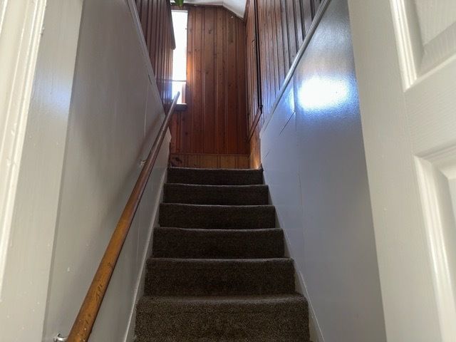 staircase featuring wooden walls