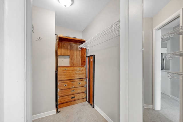 walk in closet featuring light colored carpet