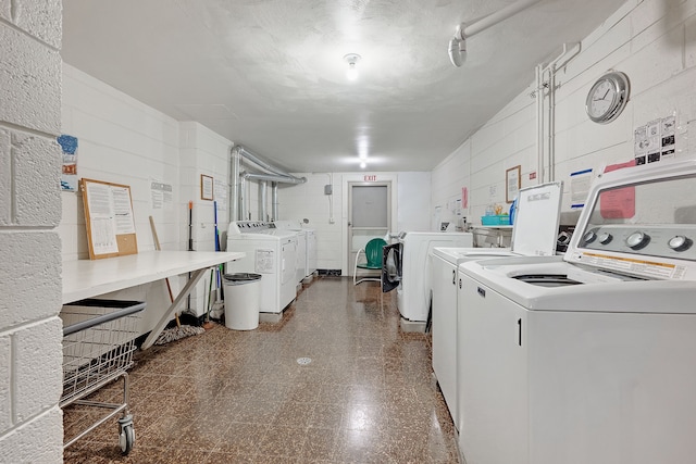 laundry area featuring a textured ceiling and washing machine and dryer