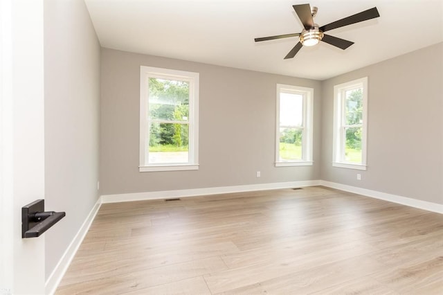 spare room with light hardwood / wood-style flooring, a wealth of natural light, and ceiling fan