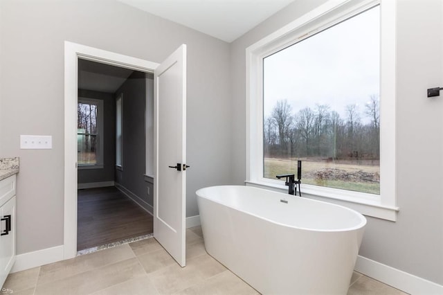 bathroom featuring a tub, tile patterned flooring, and vanity