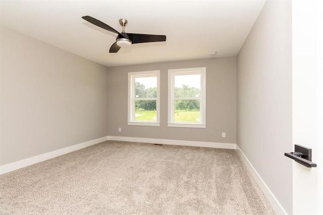 spare room featuring light carpet and ceiling fan