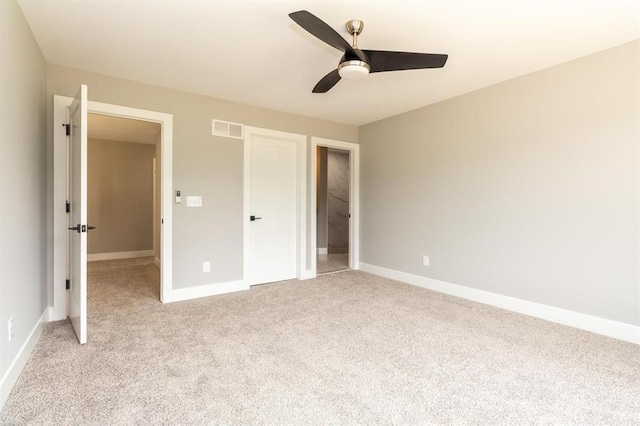 unfurnished bedroom with ceiling fan and light colored carpet