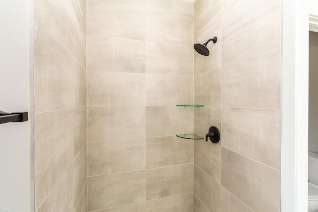 bathroom with toilet and a tile shower