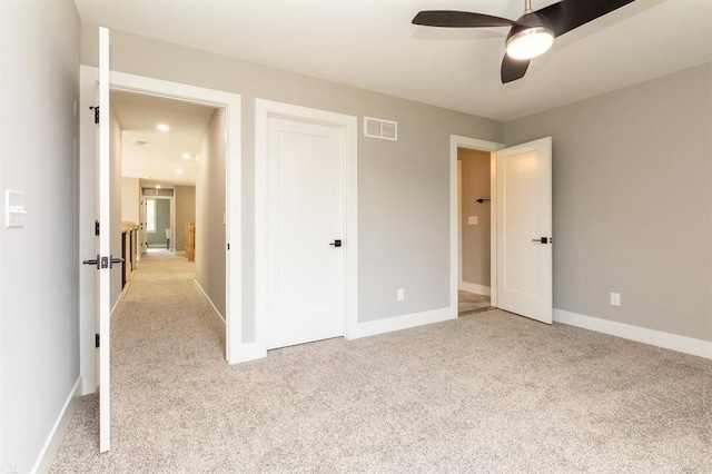 unfurnished bedroom with ceiling fan and light carpet