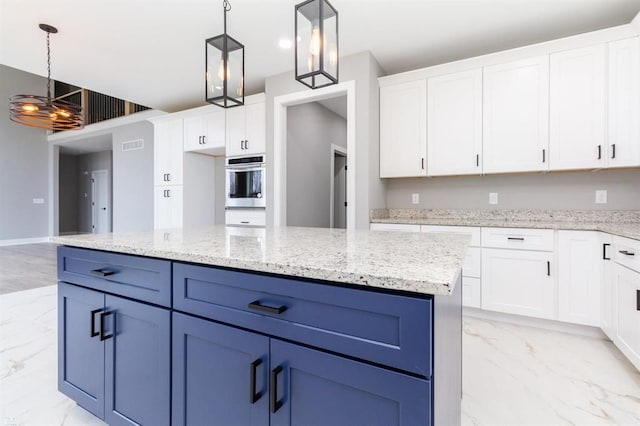 kitchen with light stone counters, double oven, pendant lighting, a center island, and white cabinetry